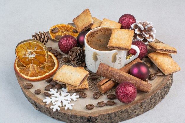 Deliciosas galletas y taza de café en placa de madera. Foto de alta calidad