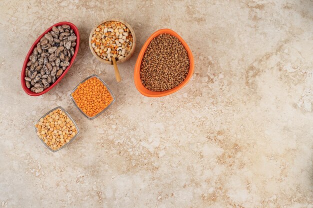 Deliciosas lentejas y frijoles en placas sobre fondo de mármol.