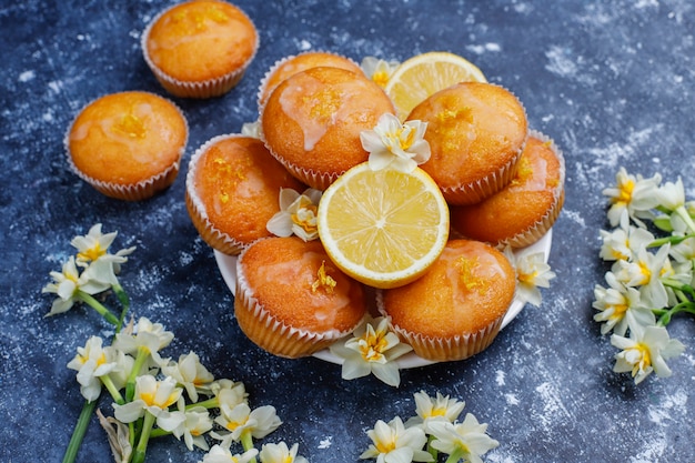 Deliciosas magdalenas de limón caseras recién horneadas con limones en un plato