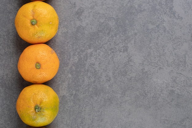 Deliciosas mandarinas enteras sobre fondo de mármol. Foto de alta calidad