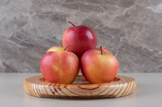 Deliciosas manzanas agrupadas en una bandeja de mármol