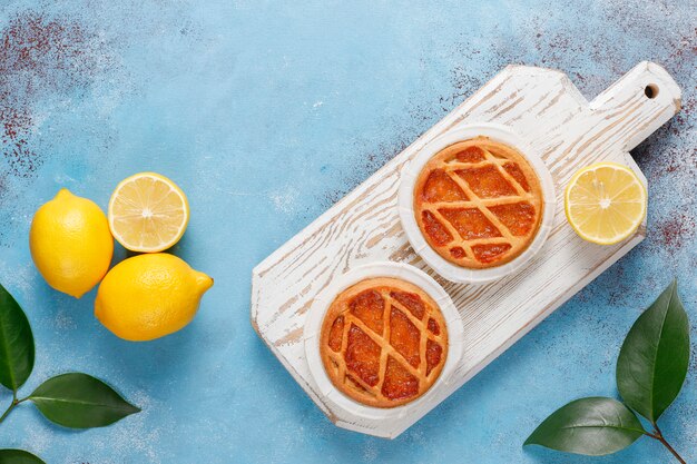 Deliciosas mini tartas de limón con limones frescos, vista superior