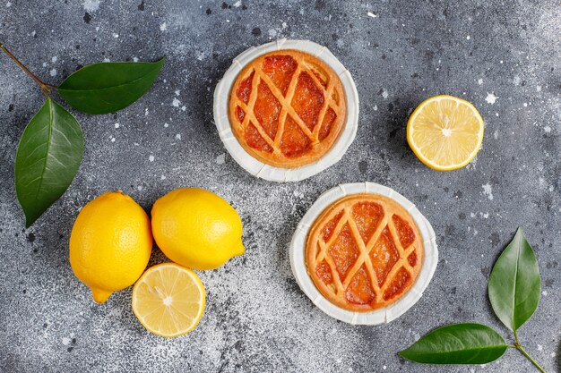 Deliciosas mini tartas de limón con limones frescos, vista superior