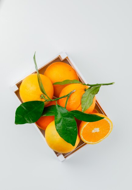 Deliciosas naranjas en una caja de madera con vista superior de la rama
