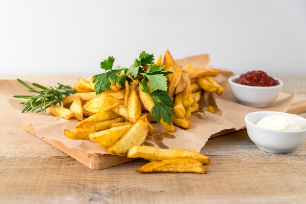 Deliciosas papas fritas con mayonesa en mesa de madera