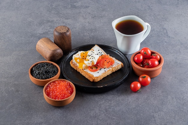 Deliciosas tostadas con tomates cherry rojos frescos y una taza de té.