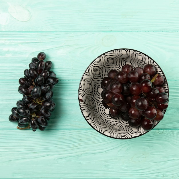 Foto gratuita deliciosas uvas en un tazón sobre fondo de madera