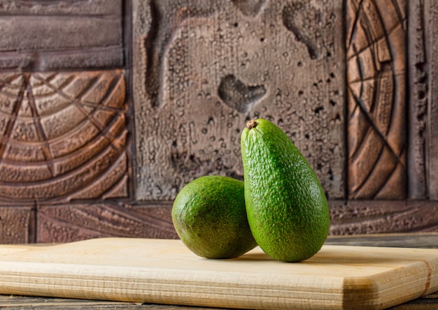 Delicioso aguacate en una vista lateral de la tabla de cortar en madera