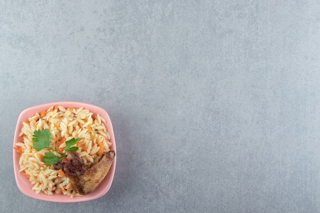 Delicioso arroz con ala a la plancha en tazón de fuente rosa.