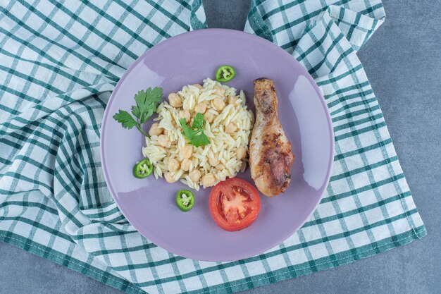 Delicioso arroz con garbanzos y muslo en plato morado.