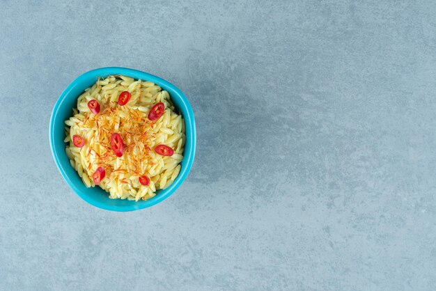 Delicioso arroz con rodajas de tomate en un tazón azul.