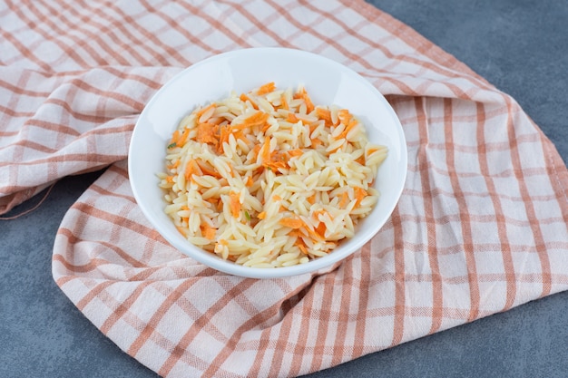 Delicioso arroz con zanahorias picadas en un tazón blanco.