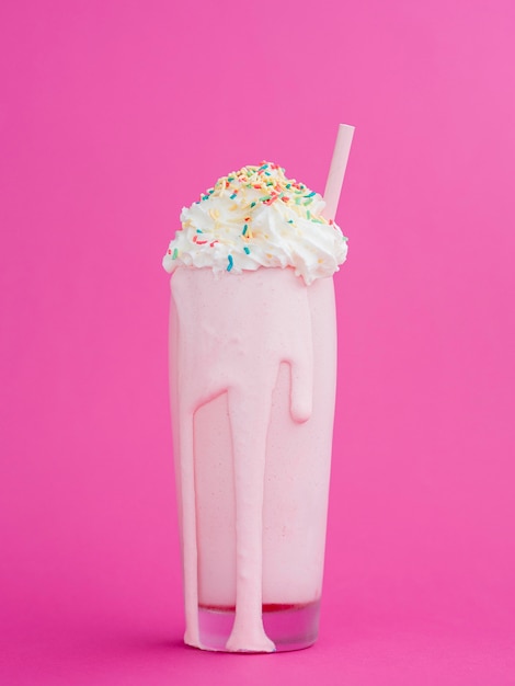 Foto gratuita delicioso batido con fondo rosa