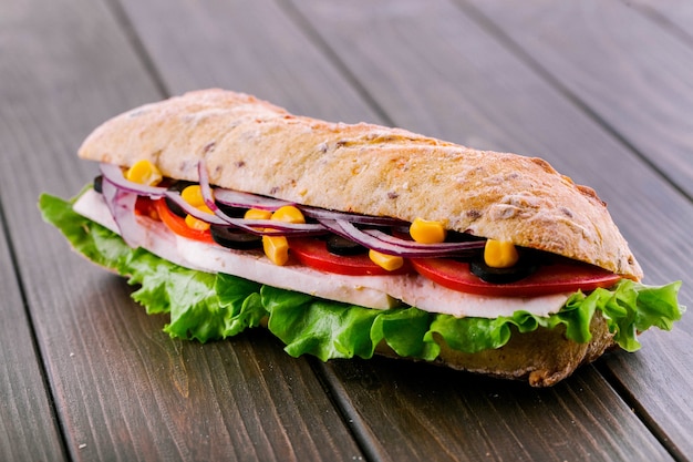 Delicioso bocadillo con cebolla azul, maíz y carne