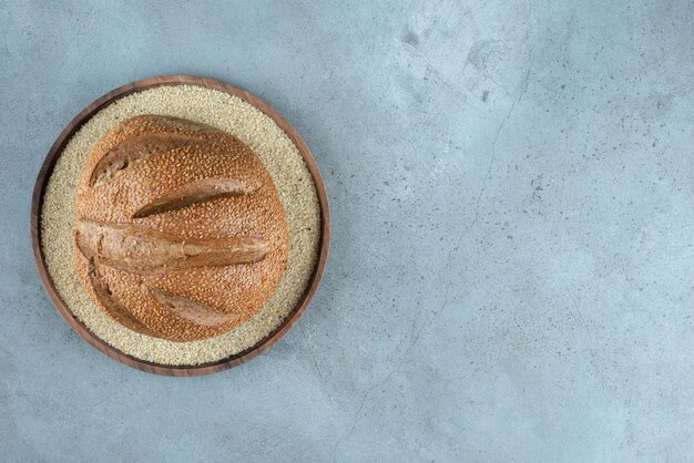 Foto gratuita delicioso bollo de centeno en placa de madera.