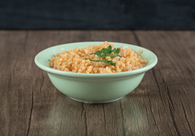 Delicioso bulgur con verduras en placa verde.