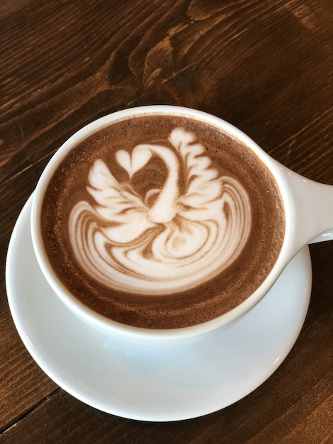 Delicioso capuchino con una hermosa pintura en la espuma.