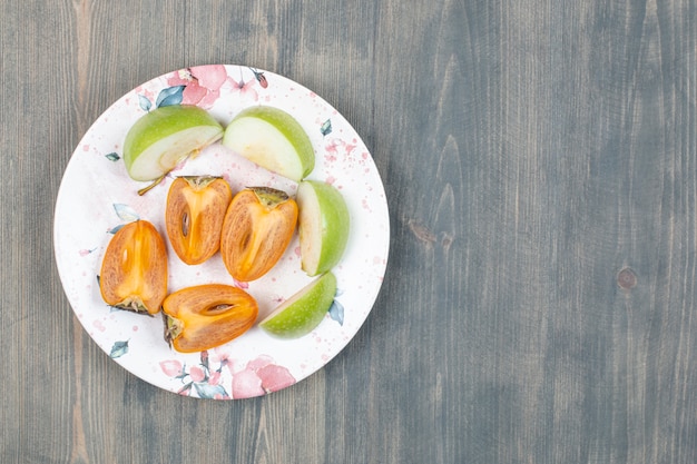 Delicioso caqui en rodajas con manzana verde en rodajas