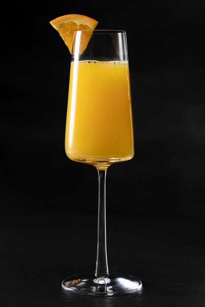 Delicioso cóctel de mimosa con rodaja de naranja