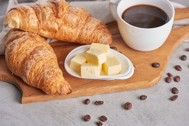 Delicioso desayuno con croissants recién hechos y café servido con mantequilla.