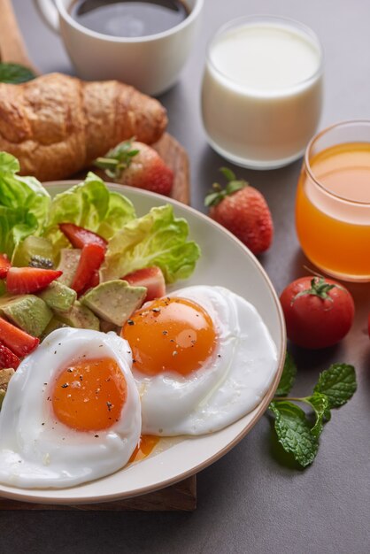 Delicioso desayuno con cruasanes recién hechos y café servido, leche, jugo de naranja.