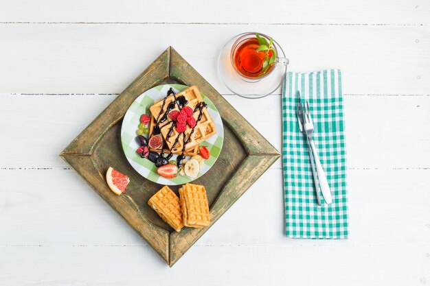 Delicioso desayuno con gofres y frutas.