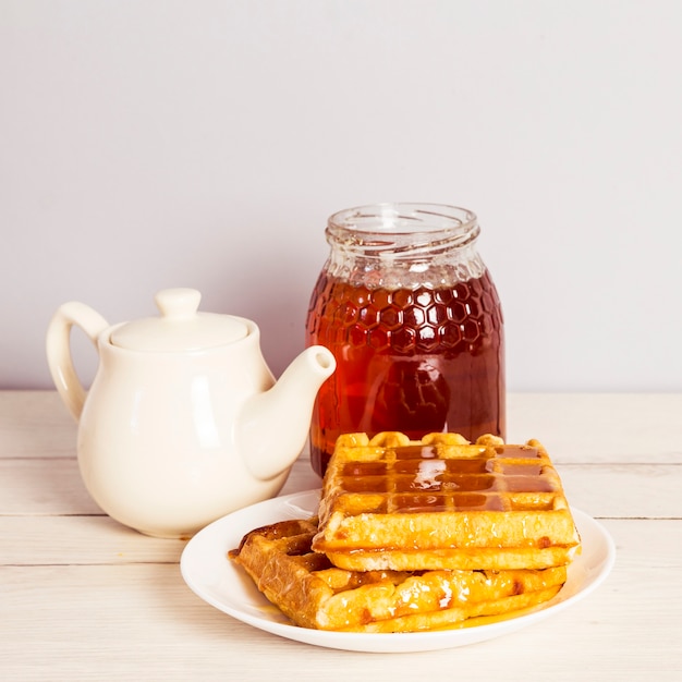 Foto gratuita delicioso desayuno con té; dulce gofre y miel