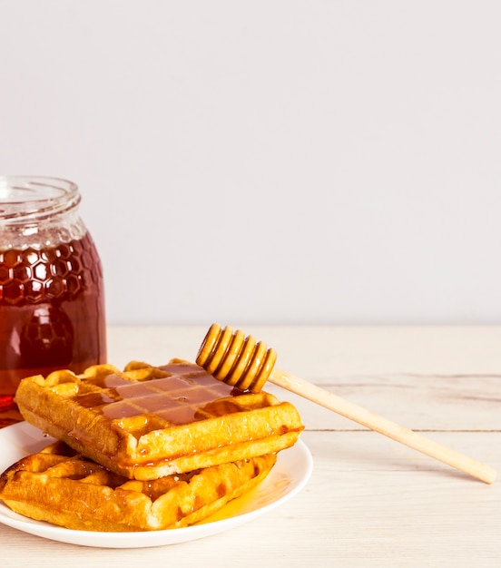 Delicioso gofre horneado con deliciosa miel en plato blanco