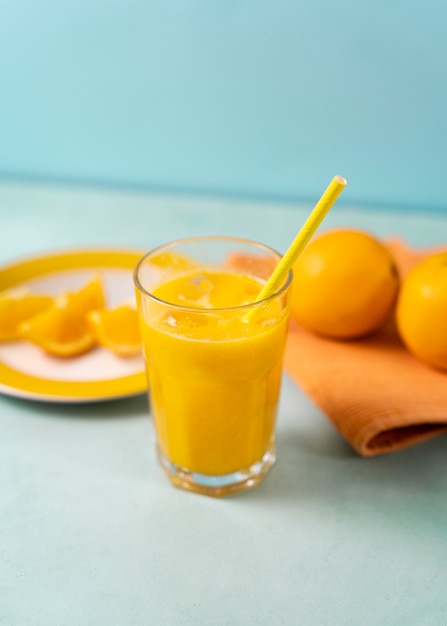 Delicioso jugo de naranja de alto ángulo con paja