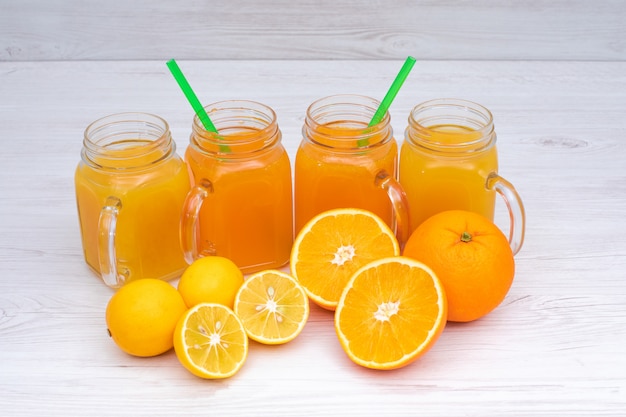 Delicioso jugo de naranja y limón en la mesa de madera blanca