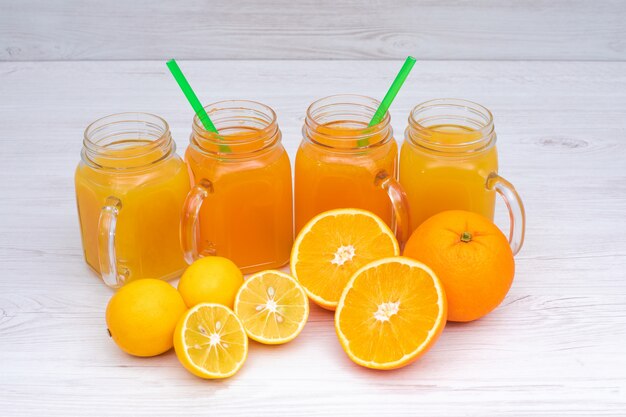 Delicioso jugo de naranja y limón en la mesa de madera blanca