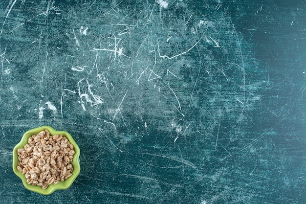 Delicioso muesli en un cuenco, sobre fondo azul. Foto de alta calidad