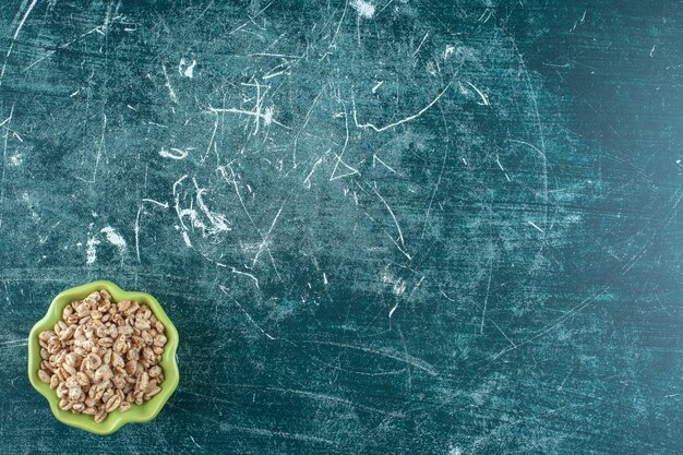 Delicioso muesli en un cuenco, sobre fondo azul. Foto de alta calidad