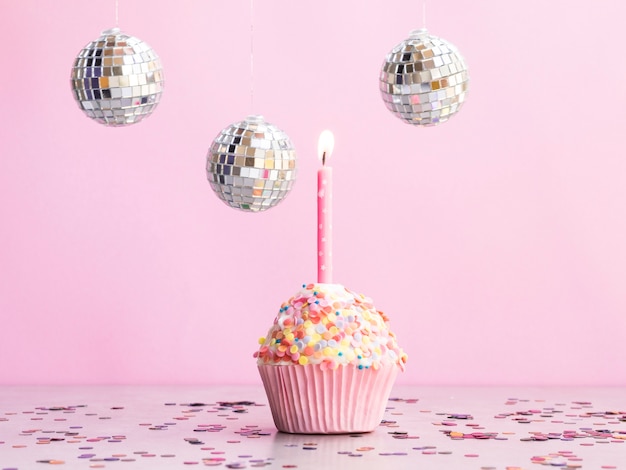 Delicioso muffin de cumpleaños con globos de discoteca