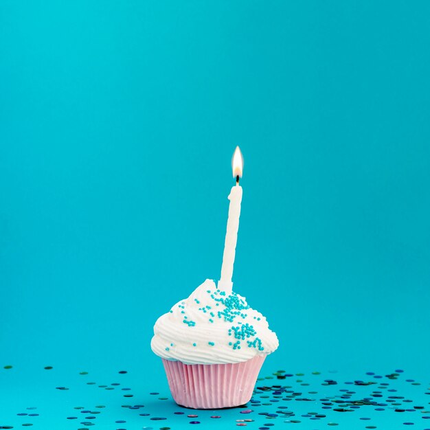 Delicioso muffin de cumpleaños sobre fondo azul.