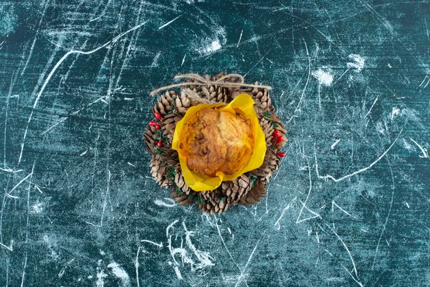 Delicioso muffin fresco y corona de Navidad sobre un fondo colorido. Foto de alta calidad