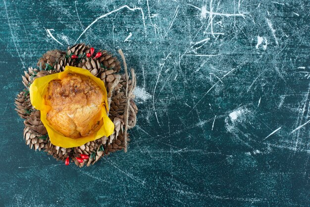 Delicioso muffin fresco y corona de Navidad sobre un fondo colorido. Foto de alta calidad