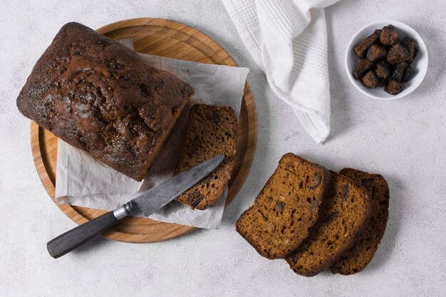 Delicioso pan dulce sobre tabla de madera con cuchillo