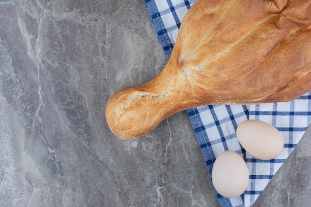 Delicioso pan fresco con huevos de gallina sobre mantel. Foto de alta calidad