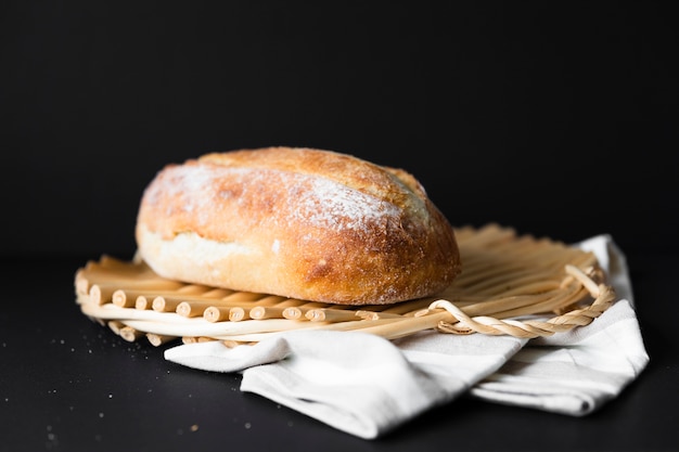 Delicioso pan de tamaño entero sobre tela y fondo negro