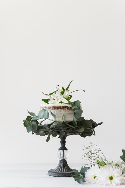 Delicioso pastel de bodas decorado con flores sobre fondo blanco