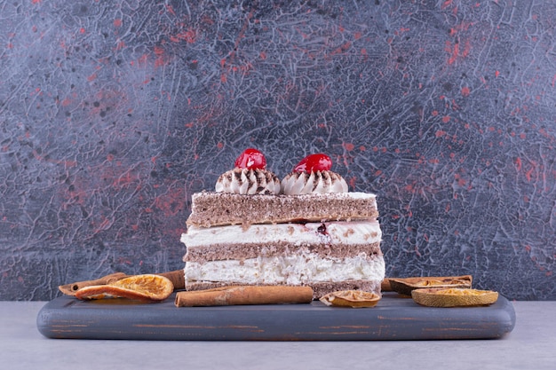 Delicioso pastel con canela y rodajas de naranja en un plato oscuro. Foto de alta calidad