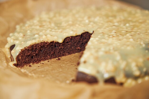 Delicioso pastel de chocolate con crema sobre una mesa blanca presentado con detalles estéticos