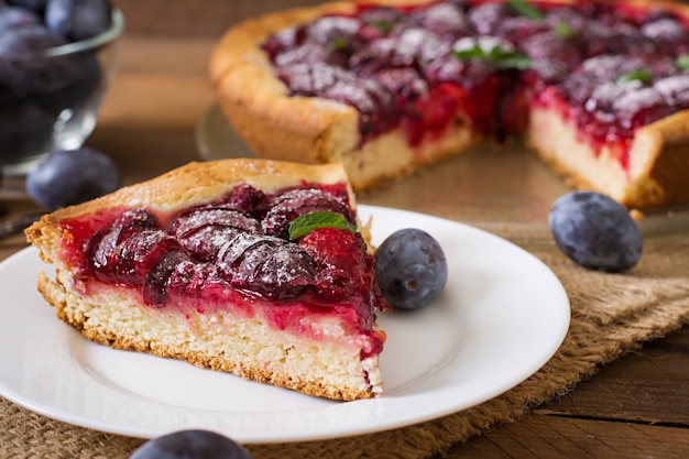 Delicioso pastel con ciruelas frescas y frambuesas