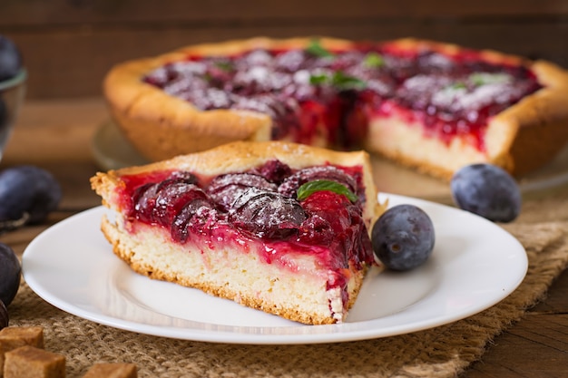 Delicioso pastel con ciruelas frescas y frambuesas