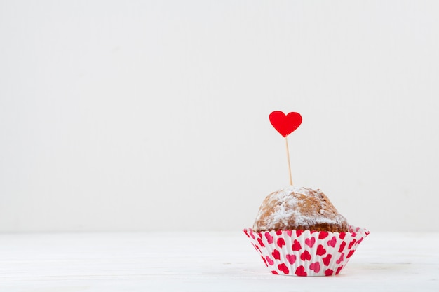 Delicioso pastel con corazón rojo en varita