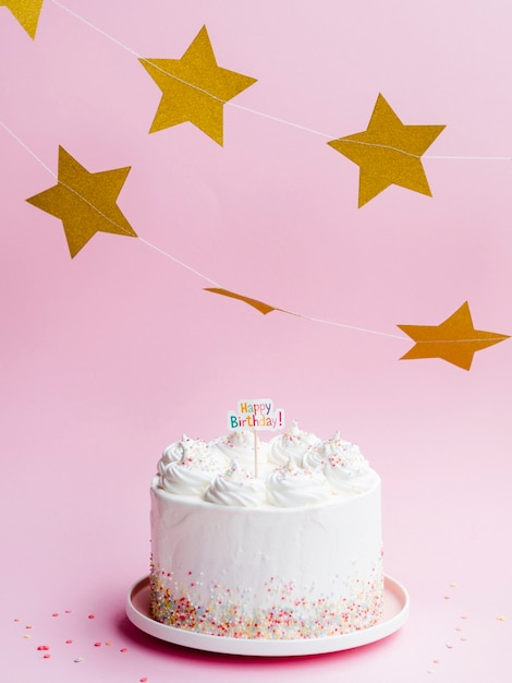 Delicioso pastel de cumpleaños y estrellas doradas