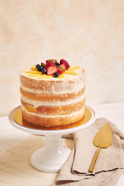 Delicioso pastel desnudo de verano mango fresa sobre una mesa blanca con blanco