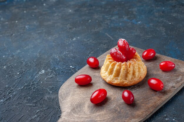 delicioso pastel dulce con cornejos rojos sobre gris oscuro