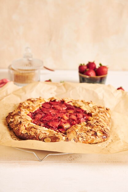 Delicioso pastel de gallate de fresas de ruibarbo con ingredientes sobre una mesa blanca